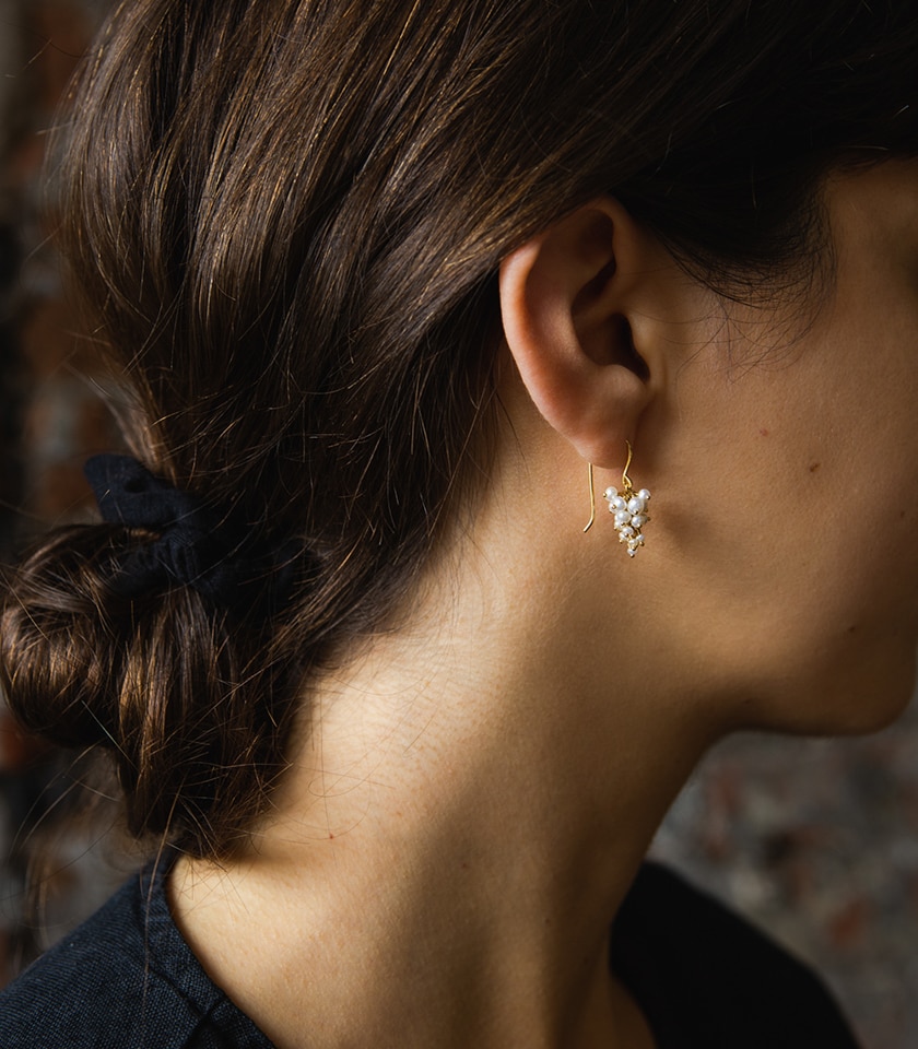 Pearl drop earrings modelled by a dark haired woman