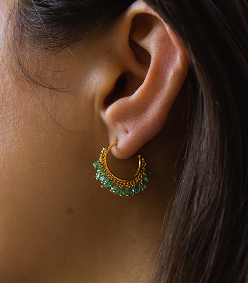 Emerald hoop earrings in gold vermeil, shown in close up on a model