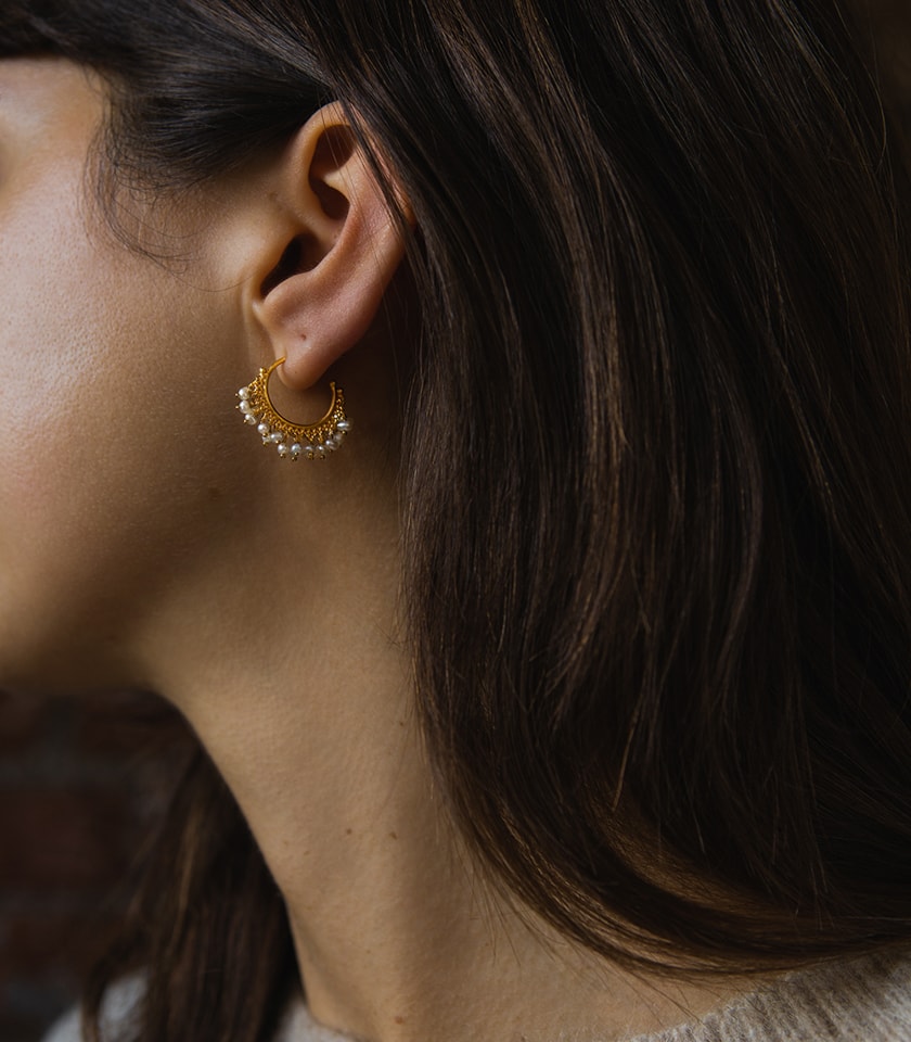 Pearl and gold vermeil hoop earrings worn by a model
