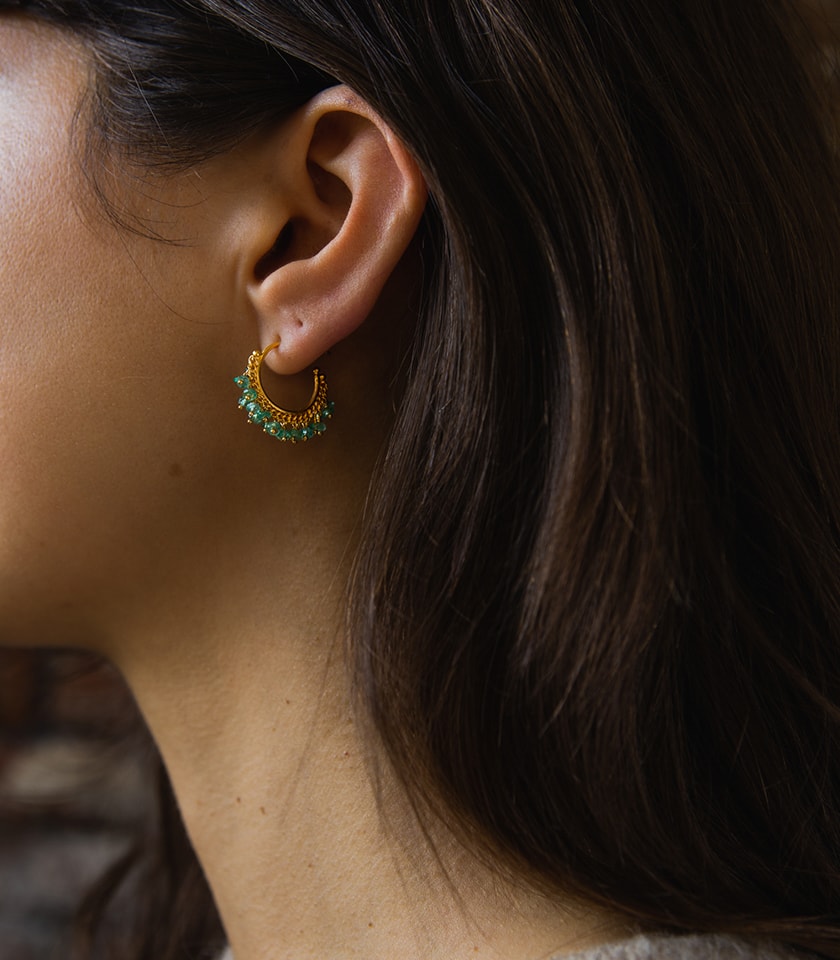 Model wearing green emerald hoop earrings