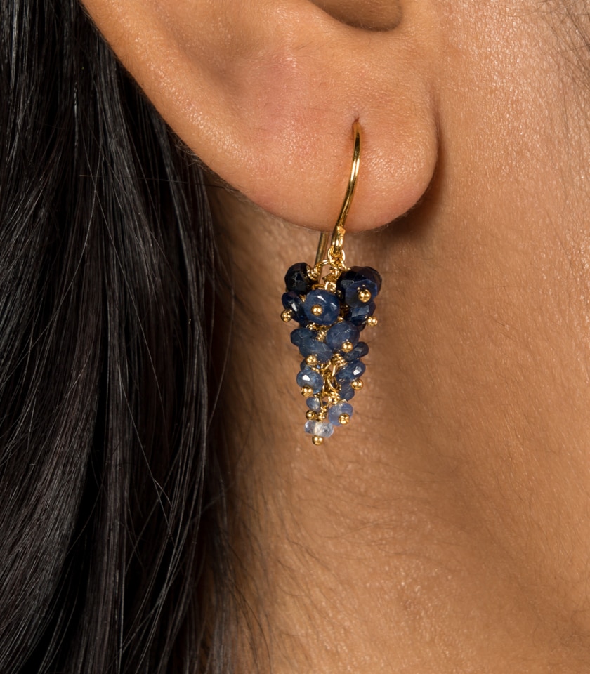 Sapphire grape earrings worn by a model in close up