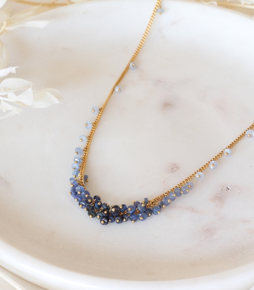 Photo of a sapphire beaded necklace on a marble tray.