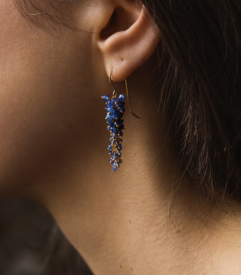 Close up of model wearing blue sapphire drop earrings