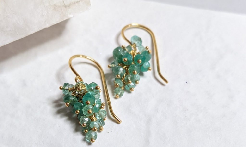 Emerald Beaded earrings on a textured white background