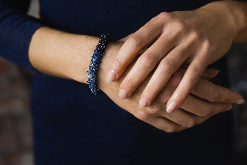 Photo of a model's hands wearing a sapphire bracelet