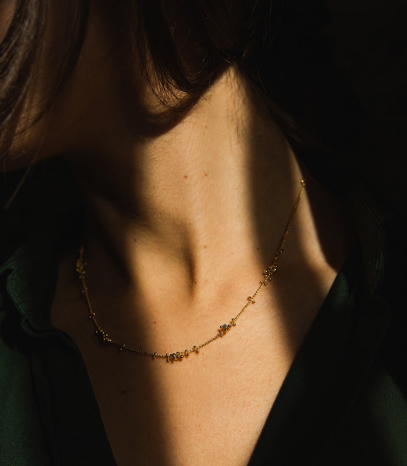 Gold plated silver and grey diamond necklace worn by a model