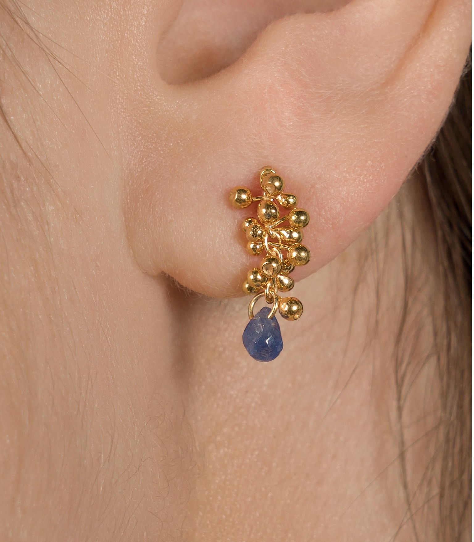 Sapphire and gold plated silver earrings worn by a model