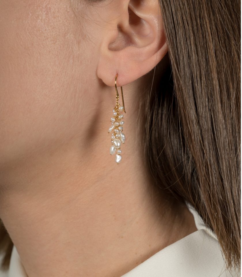 A model wearing ivory pearl earrings